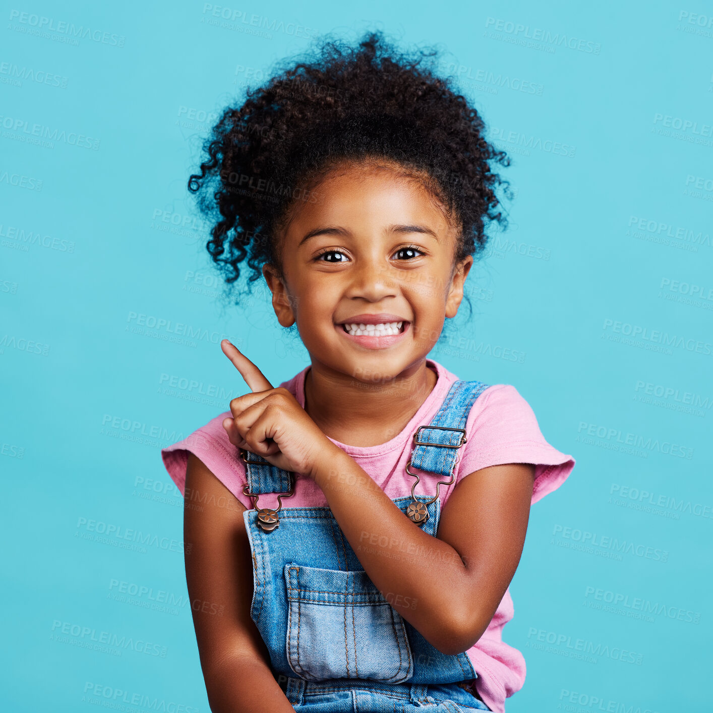 Buy stock photo Portrait, pointing and mockup with a girl on a blue background in studio showing product placement space. Kids, marketing and advertising with an adorable female child indoor to point at branding