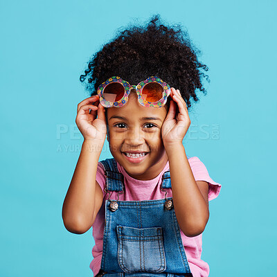 Buy stock photo Portrait, funky glasses and girl with smile, excited and cheerful against a blue studio background. Face, female child and young person with cute eyewear, trendy and happiness with joy or accessory