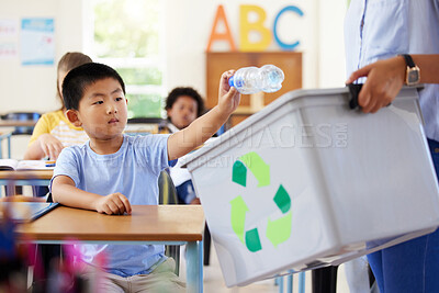 Buy stock photo Teacher, recycle bin and kid in classroom throwing trash for cleaning, climate change or eco friendly in school. Recycling plastic, sustainable learning or education with boy student in kindergarten.