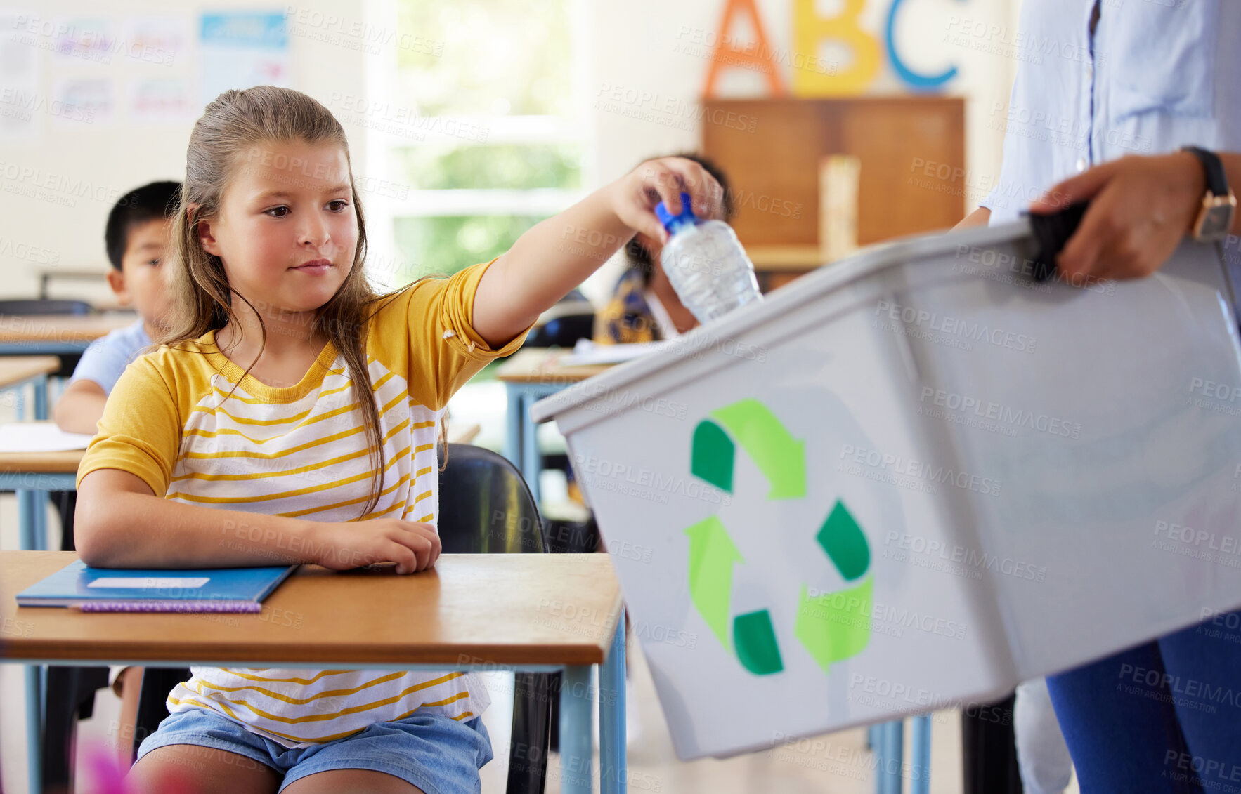 Buy stock photo Child, classroom and recycling plastic bottle with teacher for ecology, future and climate change education. Girl, box and recycle at school, class or helping hand for environment, earth and learning