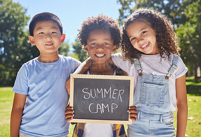 Buy stock photo Summer camp, portrait or children with board in park together for fun, bonding or playing in outdoors. Sign, diversity or happy young best friends smiling or embracing on school holidays outside