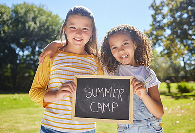 Buy stock photo Summer camp, portrait or happy girls in park together for fun bonding, development or playing in outdoors. Young best friends smiling, hugging or embracing on school holidays outside with board sign