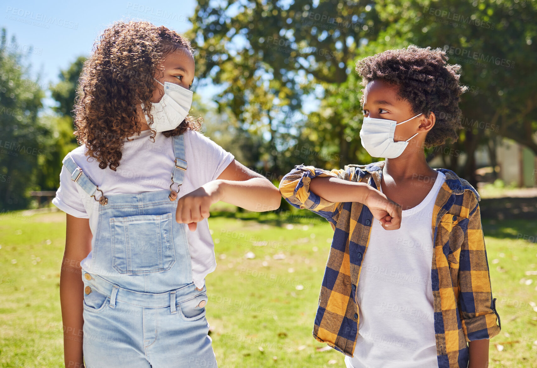 Buy stock photo Children, park and mask for covid with elbow touch with support, care or outdoor in summer sunshine. Kids, friends and greeting girl, safety and solidarity at school, playground and backyard lawn