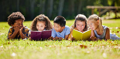 Buy stock photo Children, books and lying in park with friends, learning or diversity for reading at school playground. Kids, education or study with support, mockup space or solidarity at multicultural kindergarten