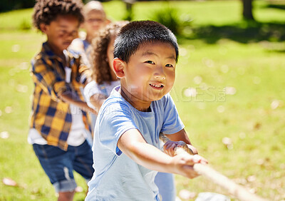 Buy stock photo Fun, games and children playing tug of war together outdoor in a park or playground during summer. Friends, diversity and kids pulling a rope while having fun or bonding in a garden on a sunny day