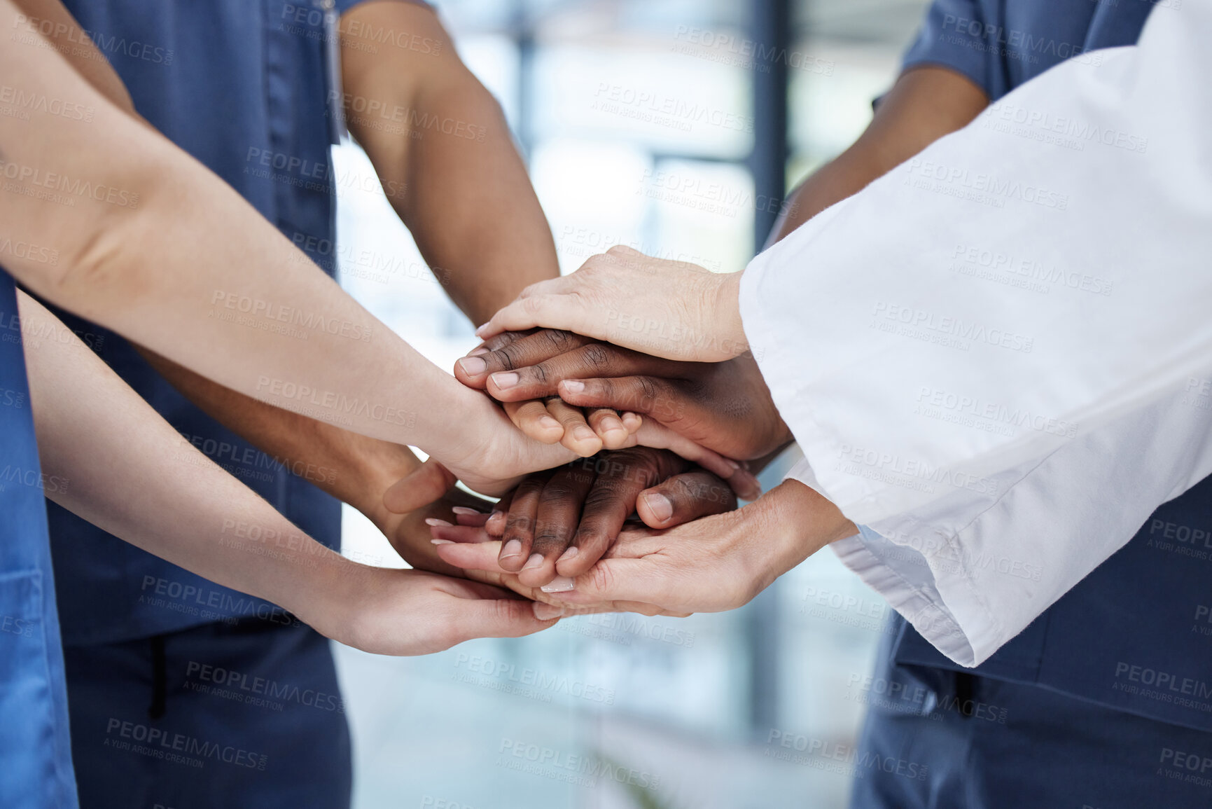 Buy stock photo Shot of a group of unrecognizable doctors stacking their hands at work