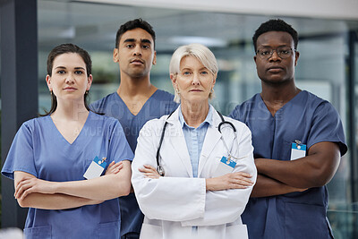 Buy stock photo Shot of a group of doctors standing with their arms crossed at a hospital