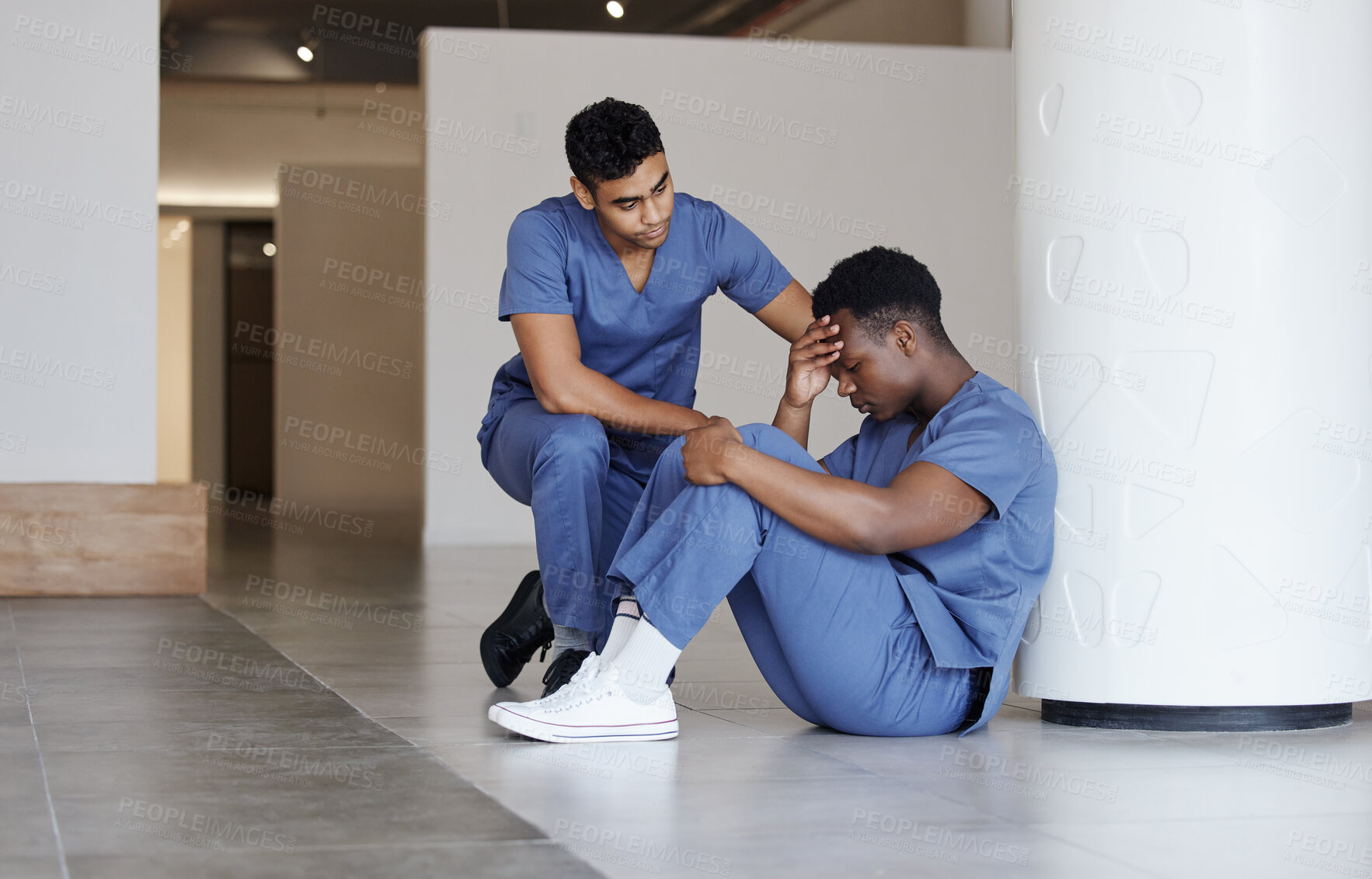 Buy stock photo Shot of a young male doctor consoling a coworker at work