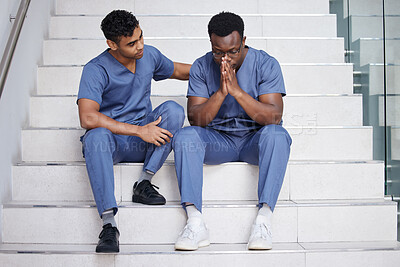 Buy stock photo Shot of a young male doctor consoling a coworker at work