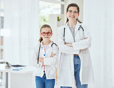 Buy stock photo Shot of a little girl and a doctor standing with their arms crossed at a hospital