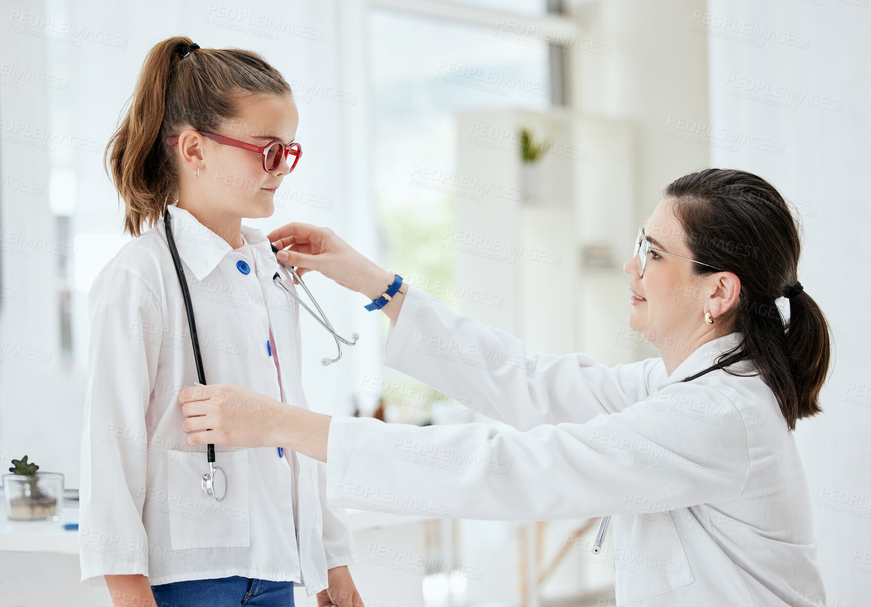 Buy stock photo Doctor, child and wear stethoscope with mother for learning health, cardiology or education. Mom, woman and medical worker with girl in hospital for checkup, test or pediatrician play on career day