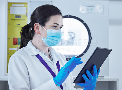 Buy stock photo Shot of a young woman working in a lab using a digital tablet