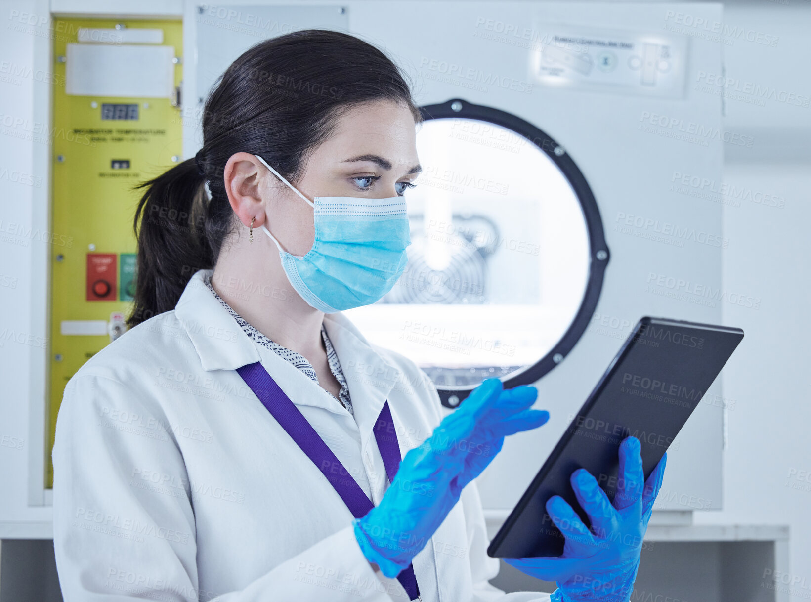 Buy stock photo Shot of a young woman working in a lab using a digital tablet