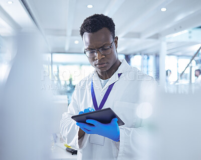 Buy stock photo Shot of a male scientist using his digital tablet