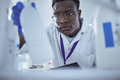 Buy stock photo Shot of a young male scientist looking for a product in his lab