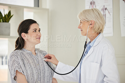 Buy stock photo Shot of a mature doctor listening to a patients heartbeat using a stethoscope