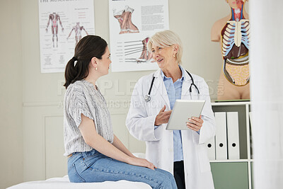 Buy stock photo Shot of a mature doctor using a digital tablet during a consultation