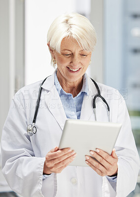 Buy stock photo Shot of a confident mature doctor using a digital tablet