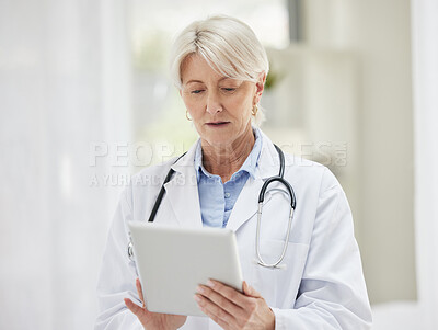 Buy stock photo Shot of a confident mature doctor using a digital tablet