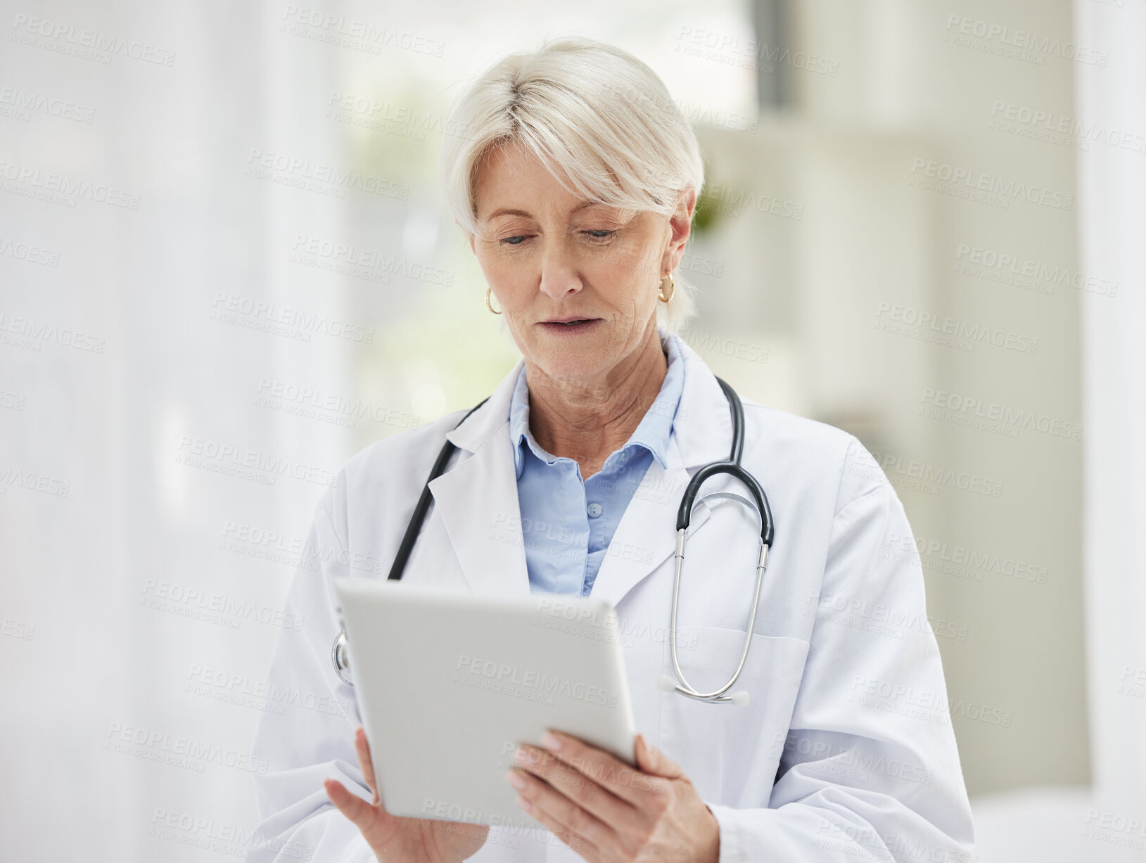 Buy stock photo Mature woman, doctor and office with tablet for patient results, report and information. Female person, medical professional and serious at clinic on website for telehealth, appointments and schedule