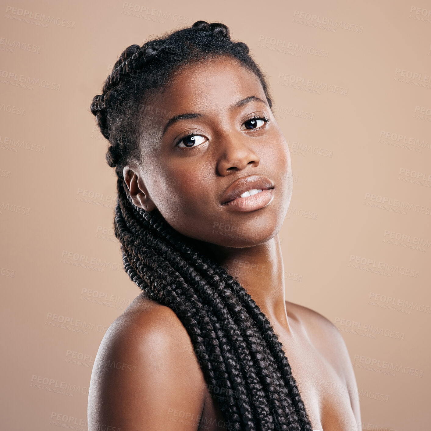 Buy stock photo Cropped portrait of an attractive young woman posing in studio against a brown background