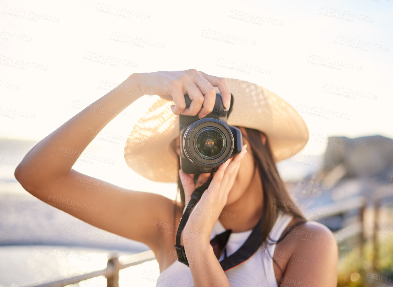 Buy stock photo Shot of a woman taking a picture with her camera while at the beach