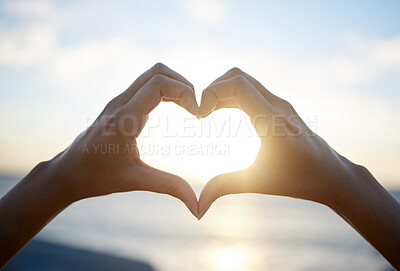 Buy stock photo Cropped shot of a woman forming a heart shape with her hands