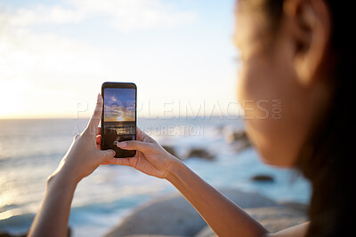 Buy stock photo Cropped shot of a woman taking a picture of the view at the beach