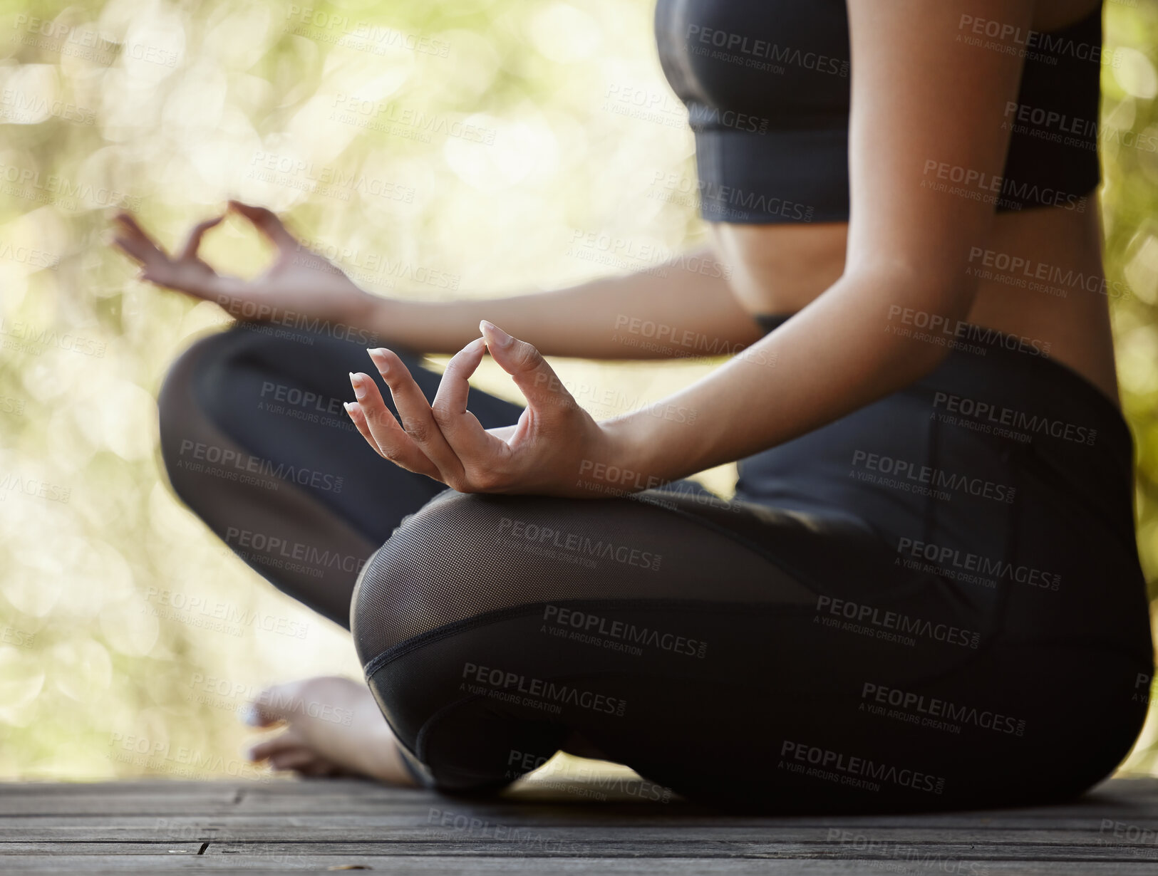Buy stock photo Cropped shot of an unrecognizable young female athlete meditating while practicing yoga outdoors