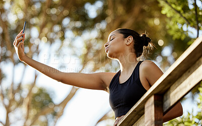 Buy stock photo Cropped shot of an attractive young female athlete taking selfies while exercising outdoors