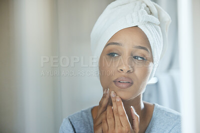 Buy stock photo Shot of a young woman popping a pimple on her face at home