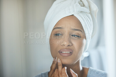 Buy stock photo Shot of a young woman popping a pimple on her face at home