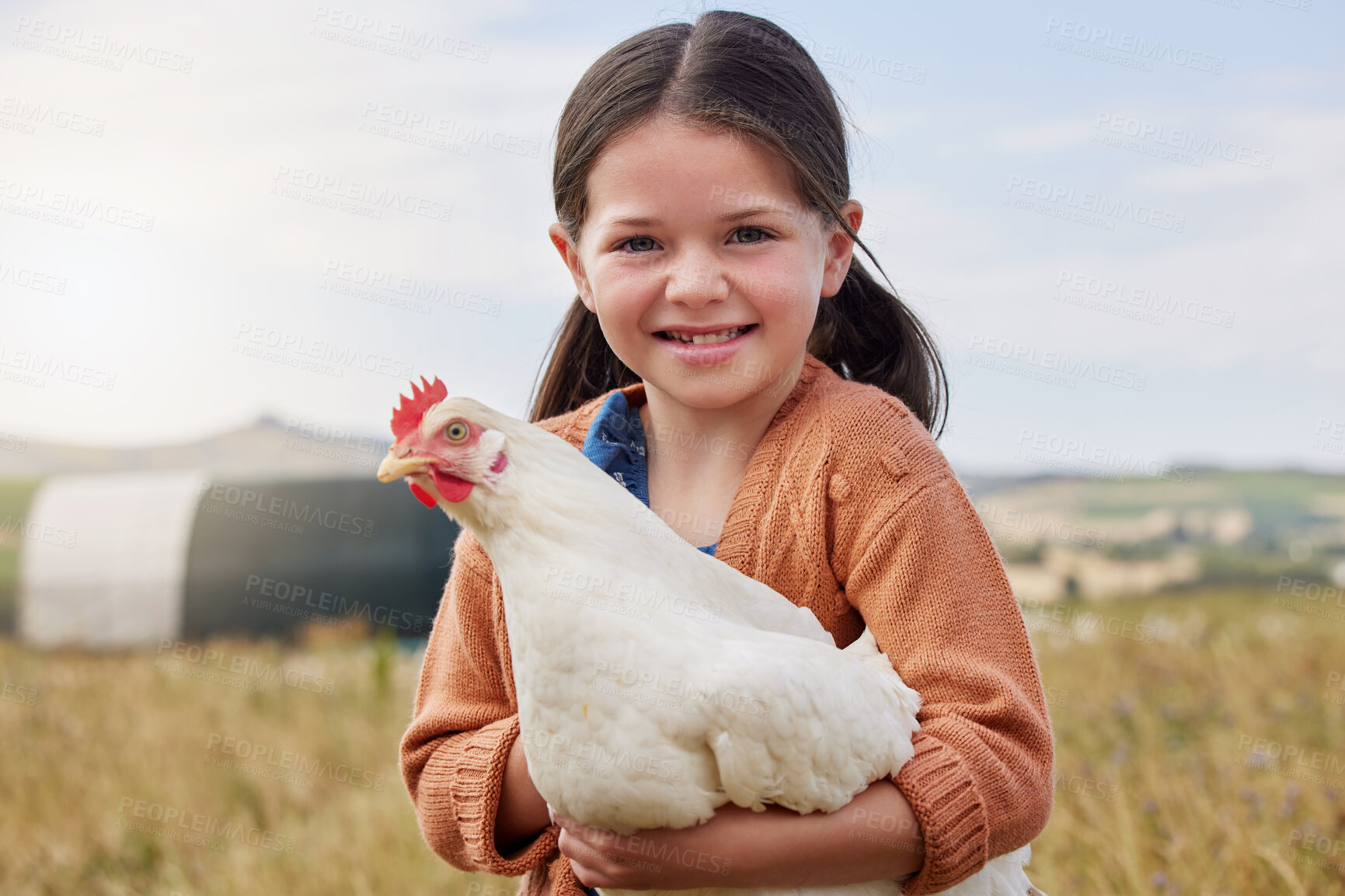 Buy stock photo Shot of an adorable little girl holding a chicken on a farm