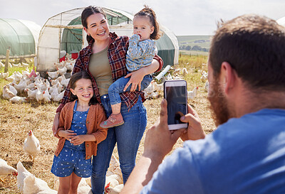 Buy stock photo Shot of a man taking a picture of his family on a poultry farm