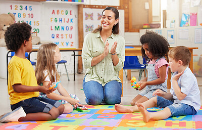 Buy stock photo Diversity, teacher with children at school and in a classroom with a lens flare. Education or learning, happiness and smile with female person with kindergarten kids playing together in a class