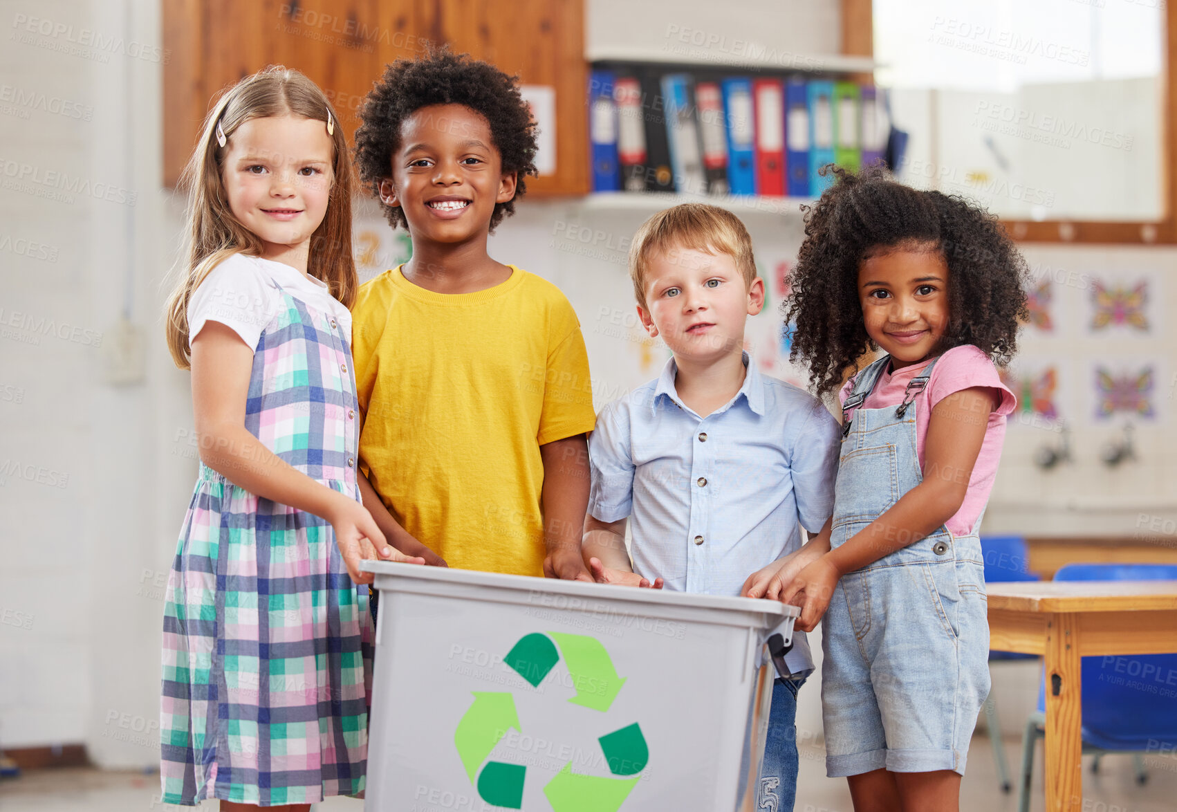 Buy stock photo Shot of a group of preschoolers holding a recycling bin in class