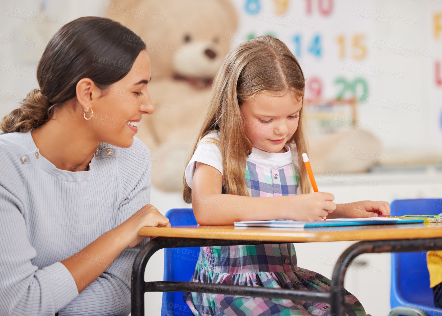 Buy stock photo Education, teacher and woman with child, classroom and writing of assignment in elementary or test. Teaching, kid and girl with notebook for knowledge, growth and development for student in school