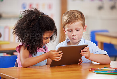 Buy stock photo Shot of two preschool students looking at something on a digital tablet together