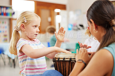 Buy stock photo Shot of a woman teaching a child about musical instruments in class
