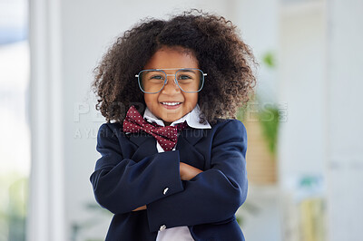 Buy stock photo Shot of an adorable little girl dressed as a businessperson standing alone in an office with her arms folded