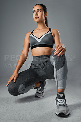 Buy stock photo Studio shot of a sporty young woman posing against a grey background