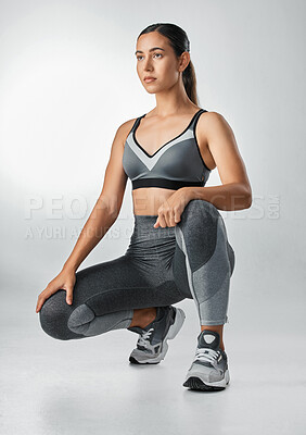 Buy stock photo Studio shot of a sporty young woman posing against a grey background