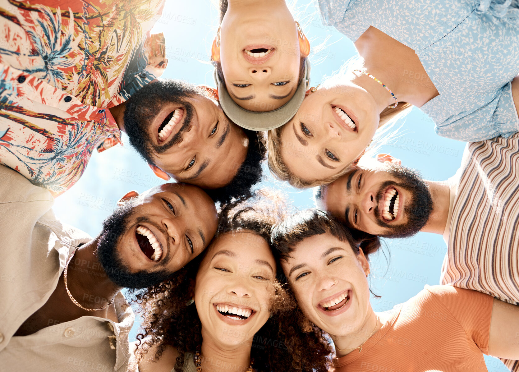 Buy stock photo Low angle shot of a diverse group of friends standing together during a day outdoors