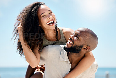 Buy stock photo Shot of a handsome young man giving his girlfriend a piggyback ride during a day outdoors