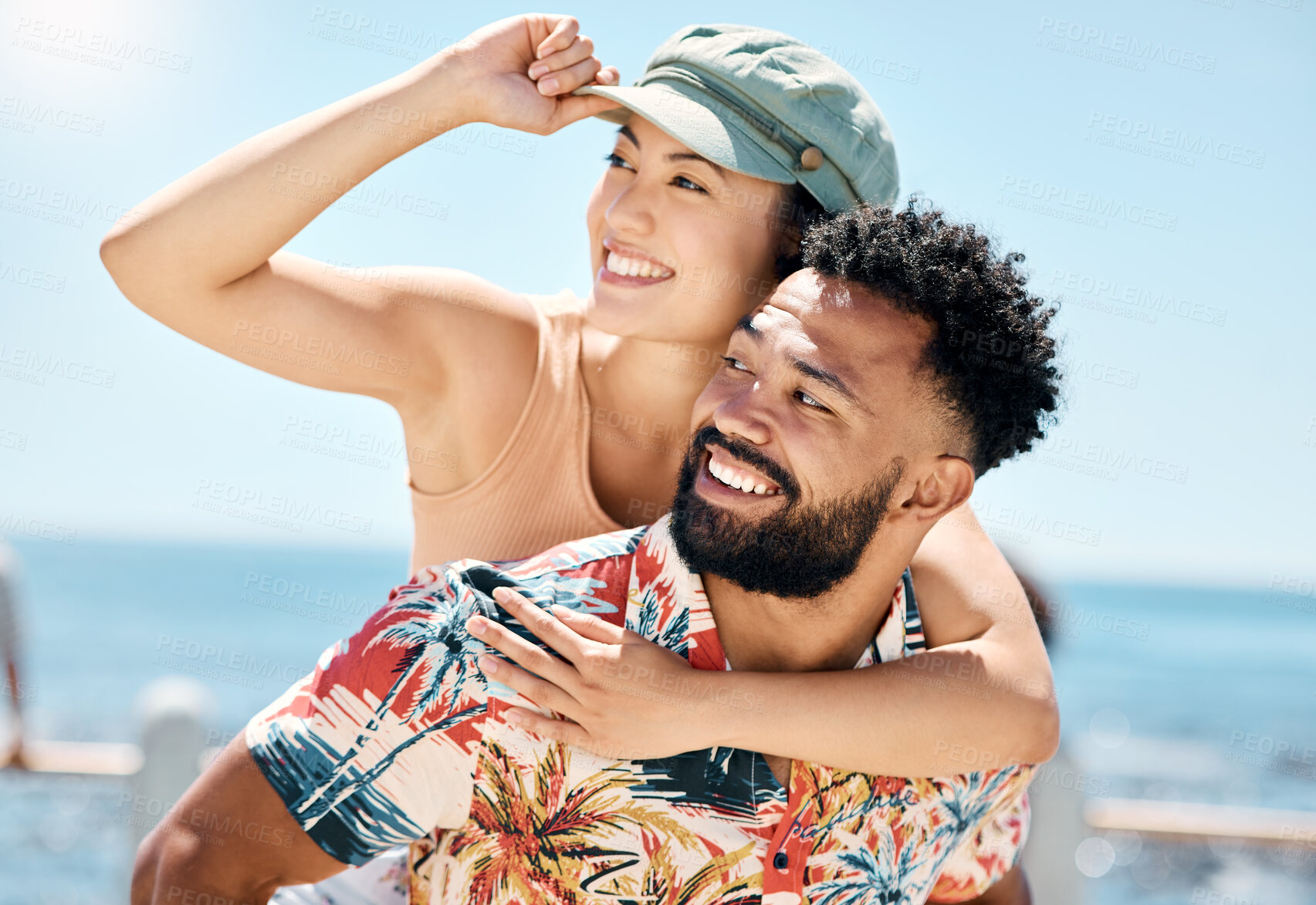 Buy stock photo Shot of a handsome young man giving his girlfriend a piggyback ride during a day outdoors