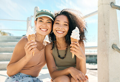 Buy stock photo Cropped portrait of two attractive young girlfriends enjoying ice creams on the beach