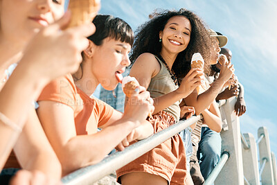 Buy stock photo Cropped portrait of an attractive young woman enjoying an ice cream on the beach with her girlfriends