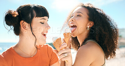 Buy stock photo Cropped shot of two attractive young girlfriends enjoying ice creams on the beach