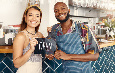 Buy stock photo Shot of two business colleagues working together holding an open sign