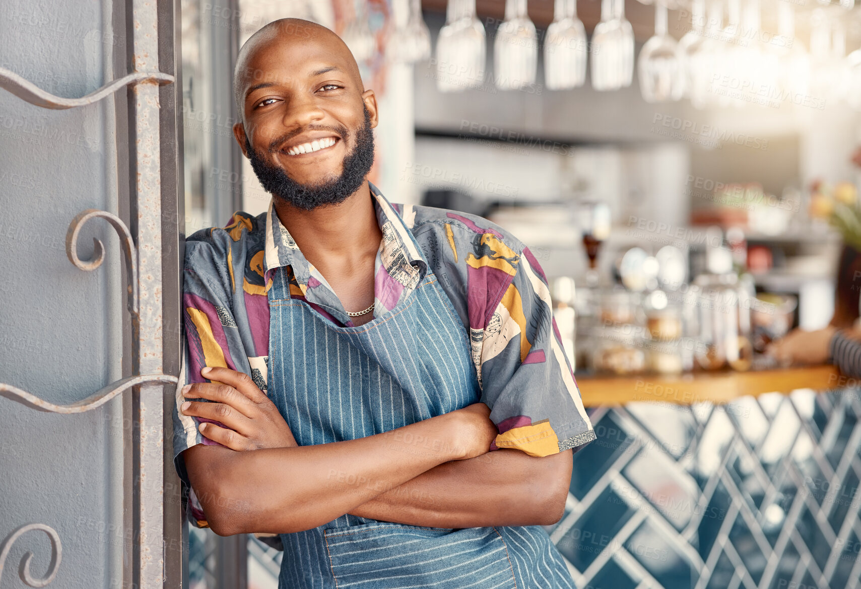 Buy stock photo Shot of a young male business owner leaning against his store entrance